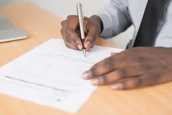 Image of a man's hand signing important documents
